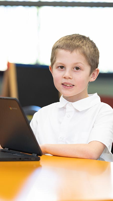 Holy Family Primary Emerton student in class using laptop