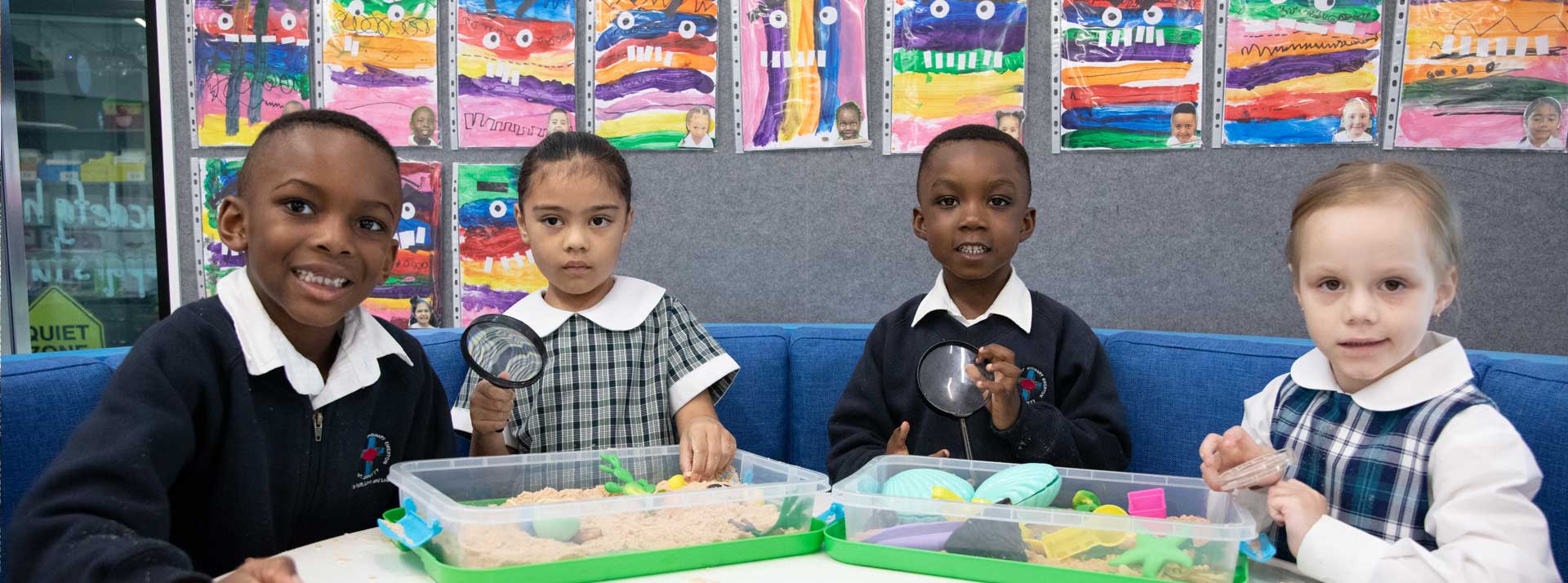 Holy Family Primary Emerton students using magnifying glass in class