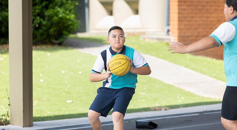 Holy Family Primary Emerton student playing basketball