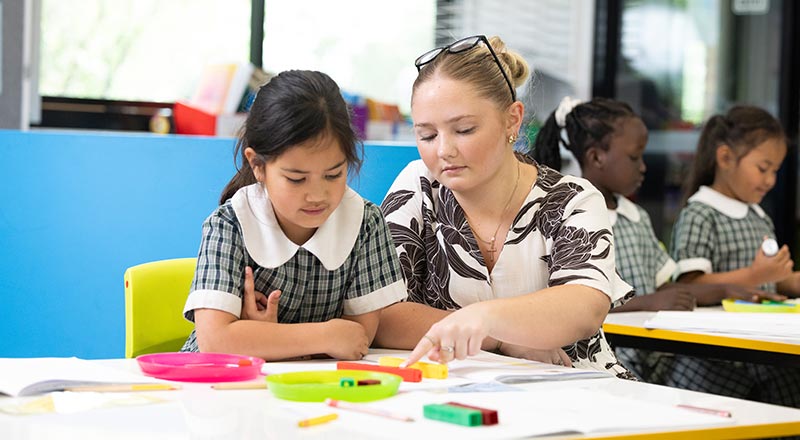 Holy Family Primary Emerton students learning in class with the assistance of a teacher