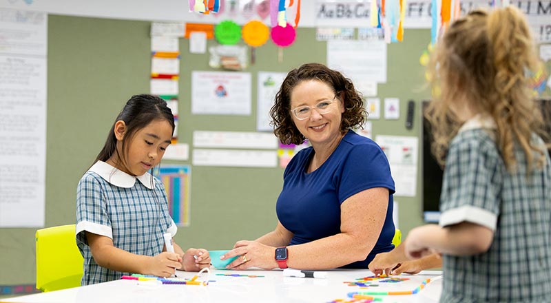 Margaret Rowan, Principal of Holy Family Primary School Emerton, assisting students in class.