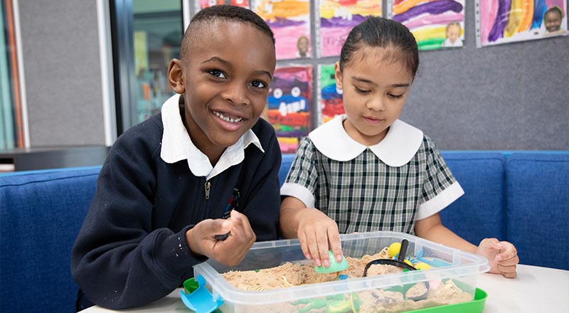Holy Family Primary Emerton students using magnifying glasses in classroom