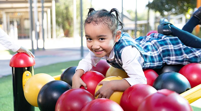 Holy Family Primary Emerton student playing on play equipment