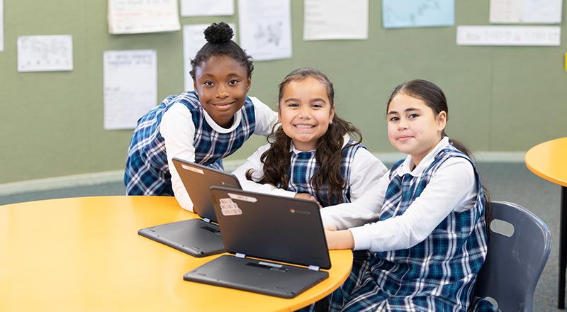 Three Holy Family Primary Emerton girls using learning devices
