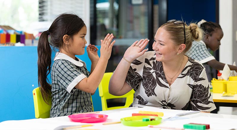 Holy Family Primary Emerton student hi-fiving a student